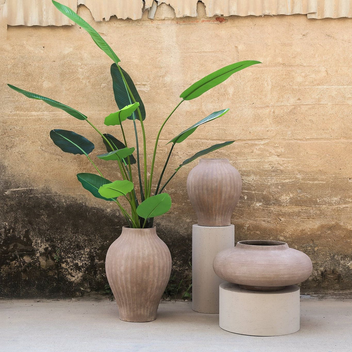 Beautii pot van PTMD in een woonsetting, bruine geribbelde pot met plant