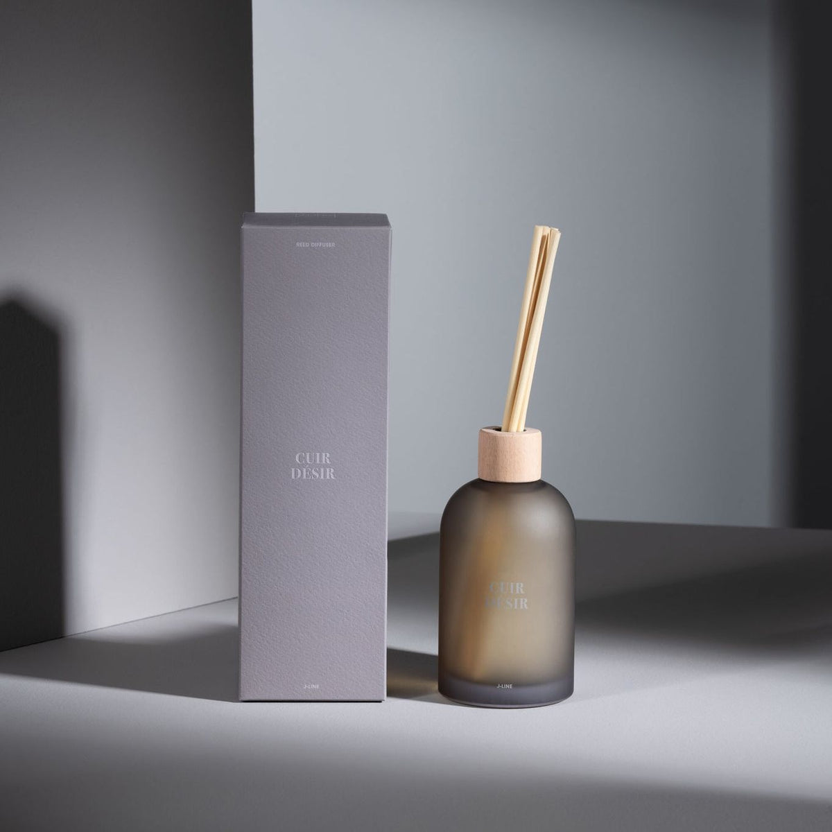 Geurstokjes Accords Essentiels Cuir Désir 250ml van J-Line met bijpassende doos in een sfeervolle bruine setting