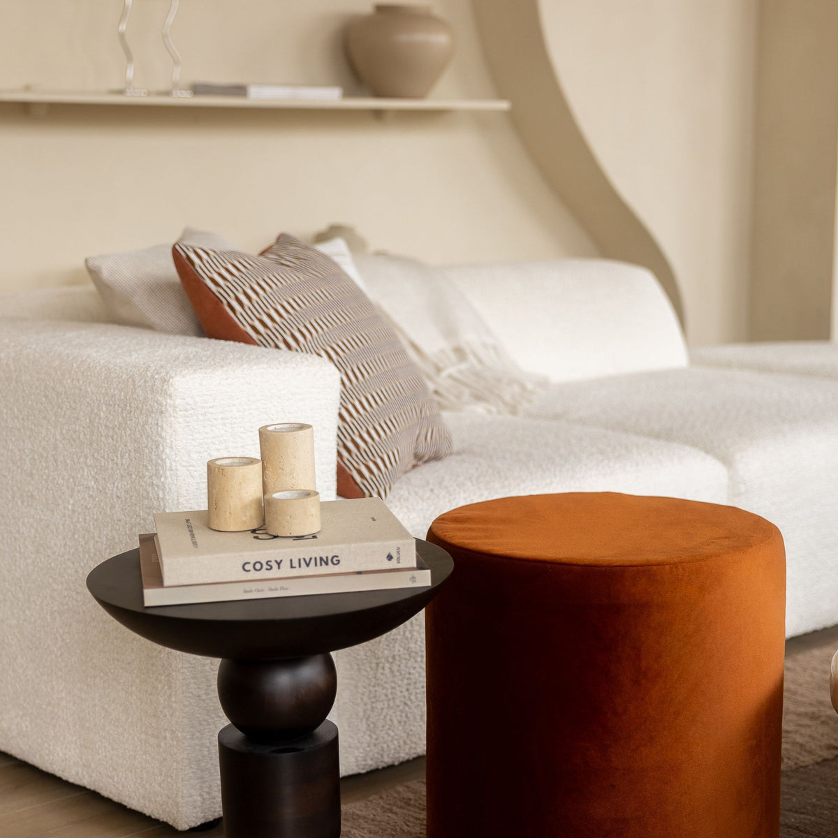 De koperkleurige velvet poef van Laui Lounge in een sfeervolle woonkamer