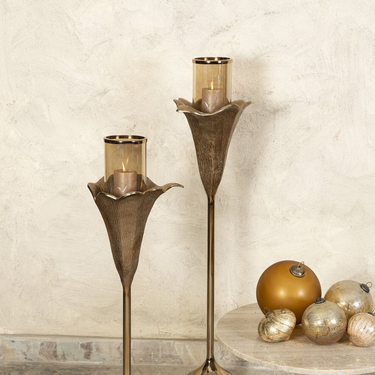 Kourtney Bronze Casted Alu Stormlight Flower L van PTMD, bronskleurig windlicht in bloemvorm in een sfeervolle interieursetting