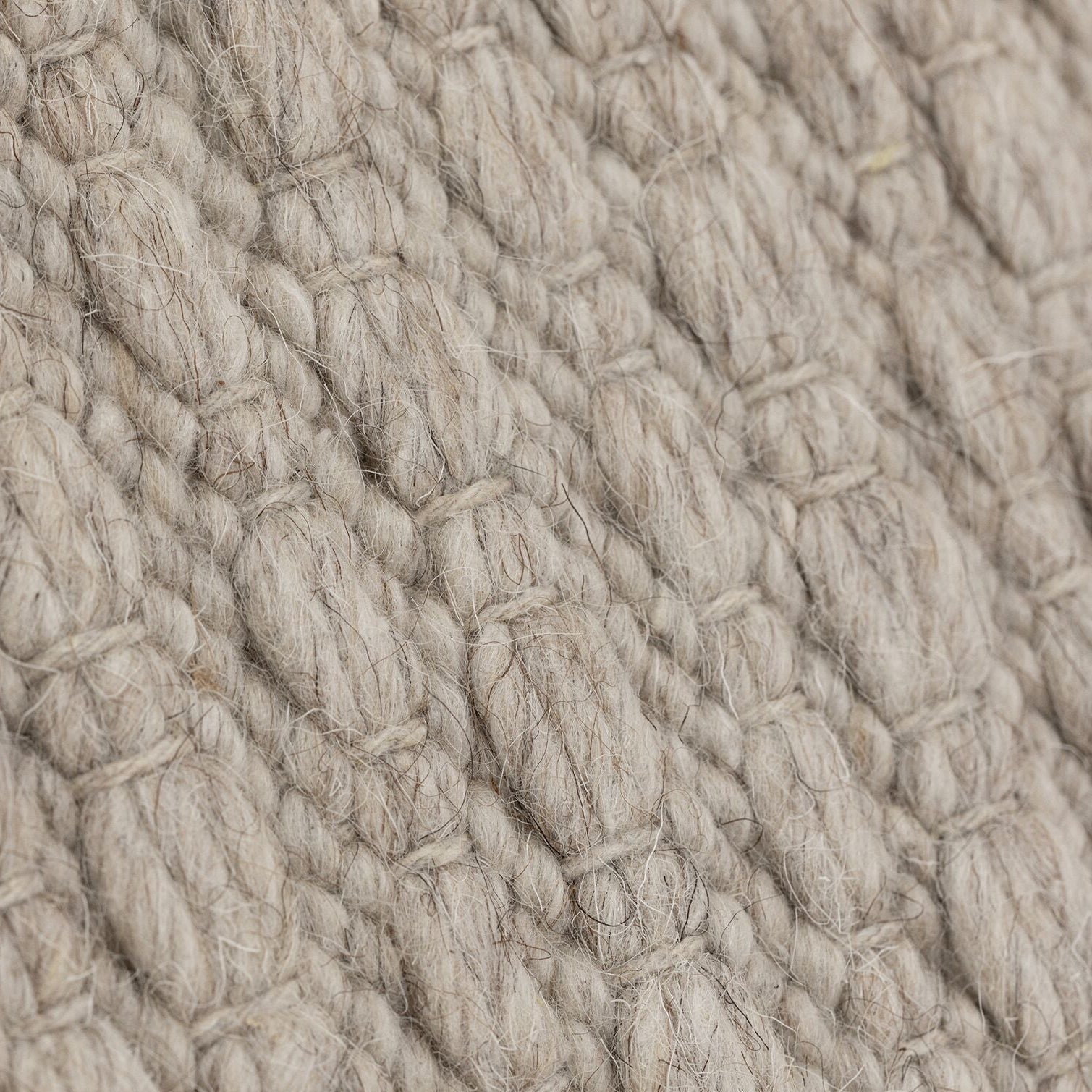 Nirvana vloerkleed van MUST Living in beige, detail van het gevlochten reliëfpatroon in de weving