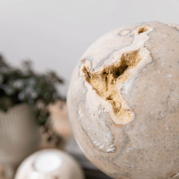Object Ball Cheese Stone van MUST Living in een gestylede setting op een kast