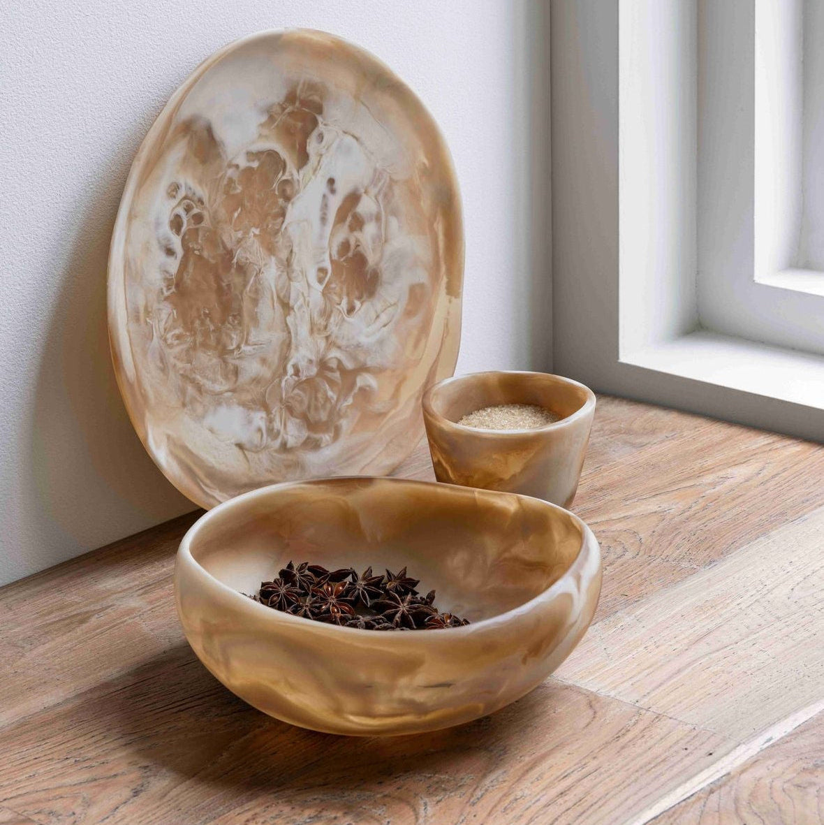Schaal Rafael van MUST Living, sfeerbeeld met de bruin witte resin schalen en het dienblad uit de Rafael serie