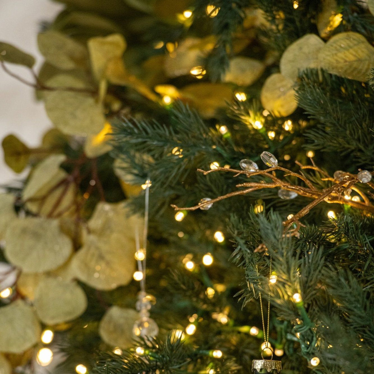 Kerstbal Geruit Glas Small van J-Line hangend in een kerstboom met warme lichtjes