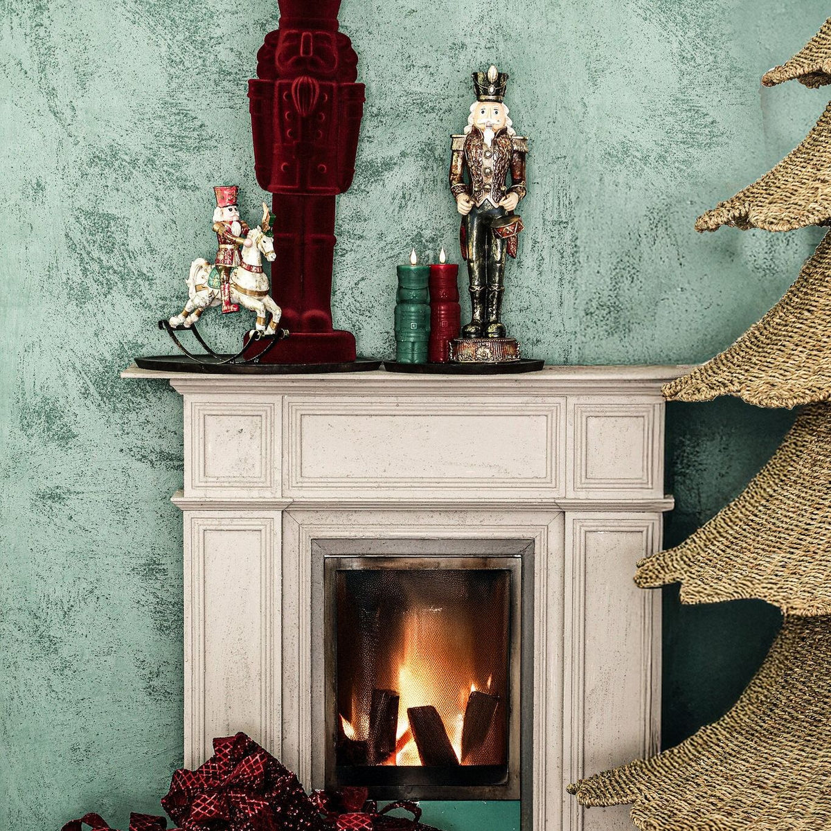 Yule Notenkraker Bordeaux Small van PTMD, sfeerbeeld bij een open haard met fluwelen kerstdecoratie