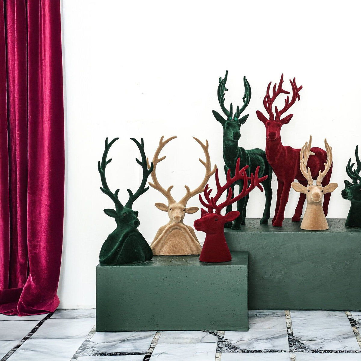 Yule Rendierkop Donkergroen Large van PTMD, rendieren en kerstboompjes in drie kleuren op een groene kast