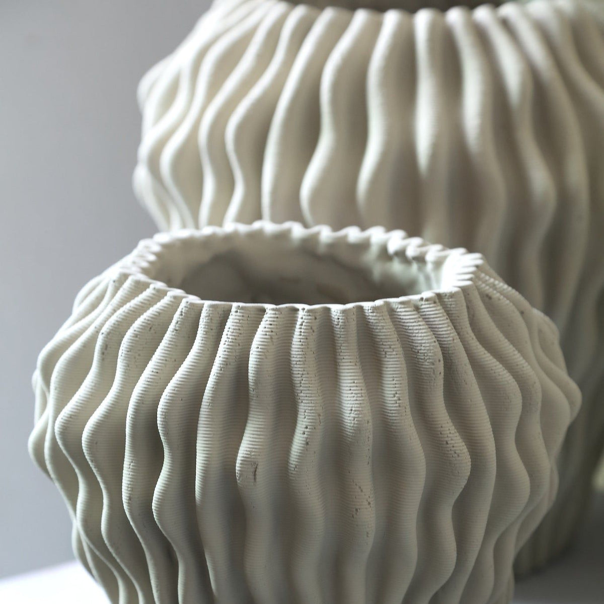 Barren Beige Cement Round Vase 3D Wavy Pattern L van PTMD, sfeerfoto op een dressoir