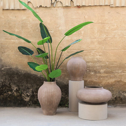 Beautii pot van PTMD in een woonsetting, bruine geribbelde pot met plant