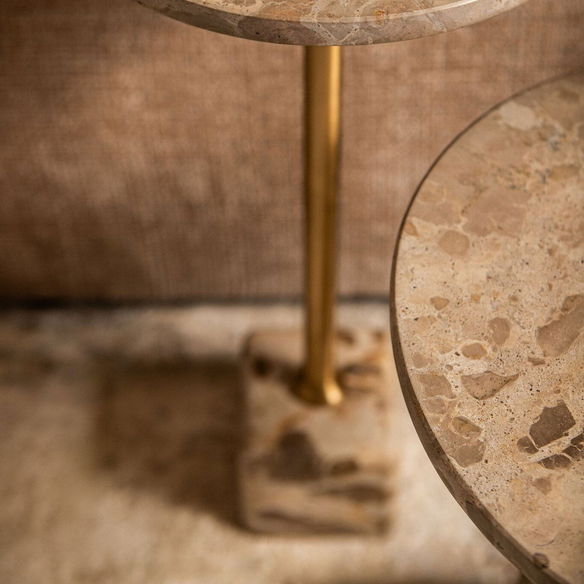 Detail van de Ebe bijzettafel van PTMD, marmeren voet en blad met goudkleurige stang