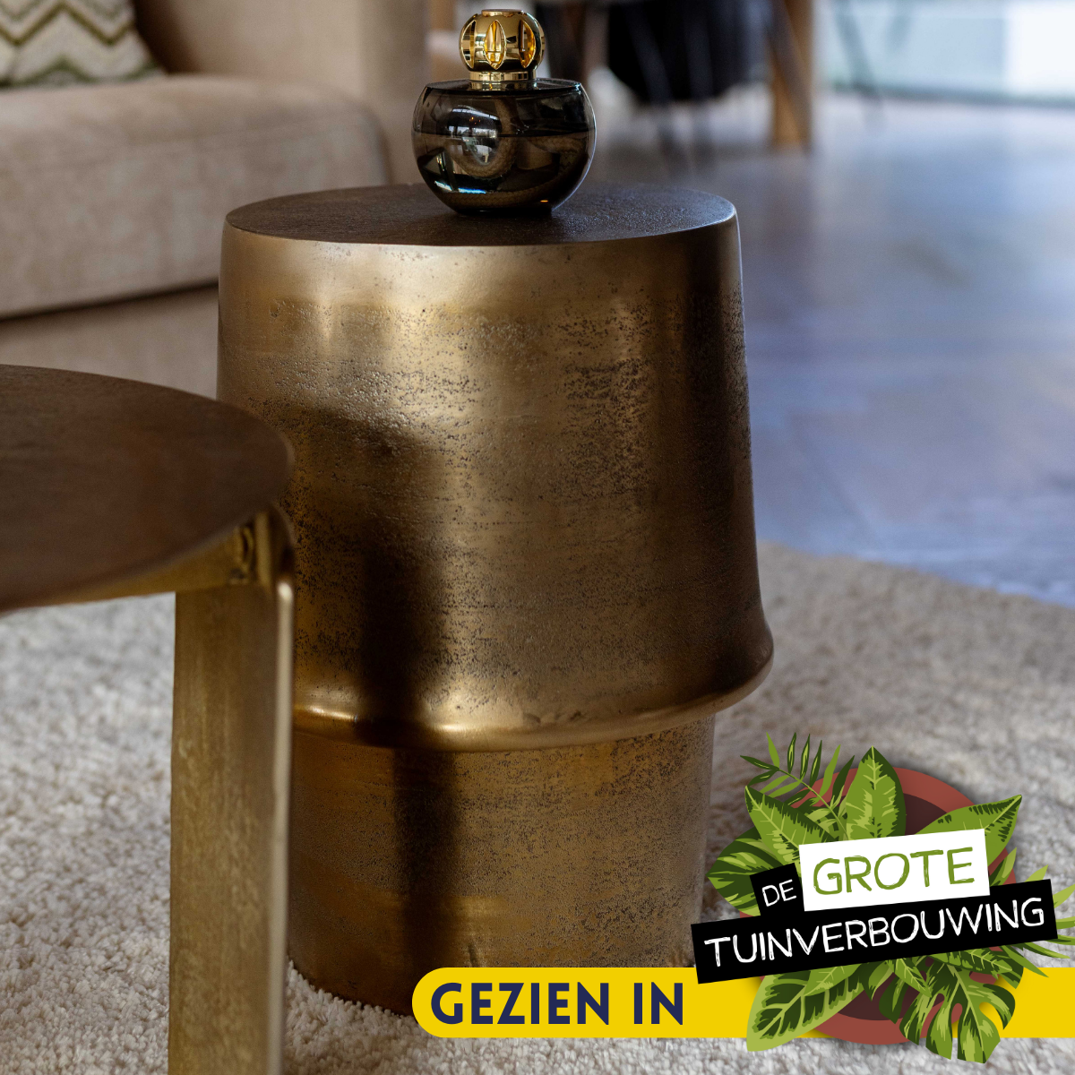 Bijzettafel Glamor van Starfurn in een woonkamer, naast een fauteuil met een kussen