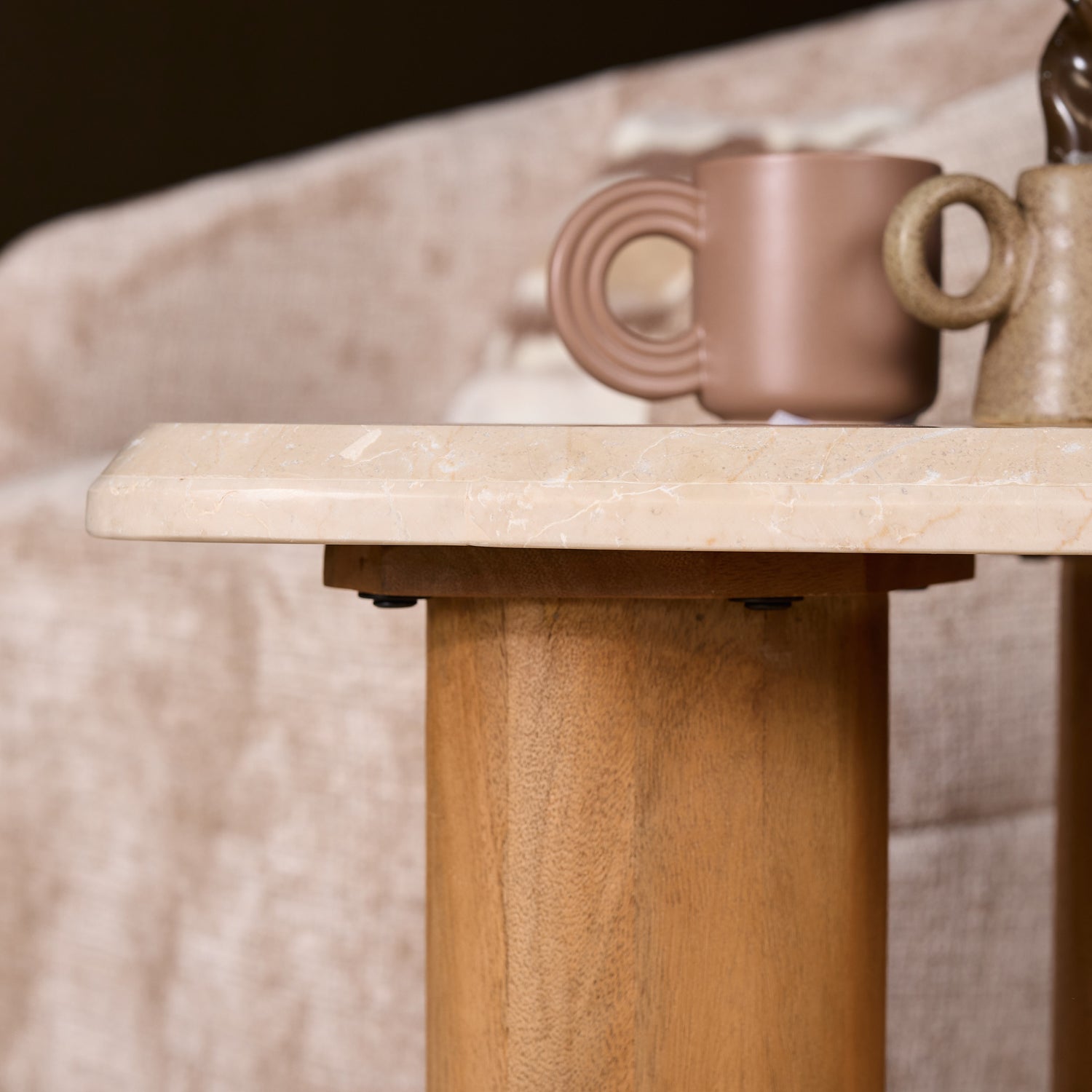 Bijzettafel Nuvé van Starfurn gestyled met een kaars en een boek op het beige marmer