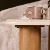 Bijzettafel Nuvé van Starfurn gestyled met een kaars en een boek op het beige marmer