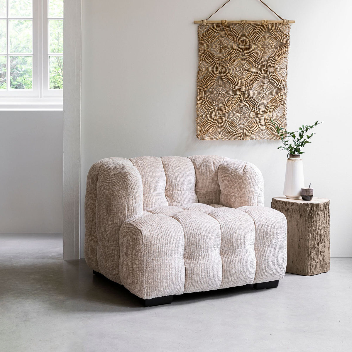 Bijzettafel Rocca van MUST Living in een interieur naast een fauteuil en wandpaneel