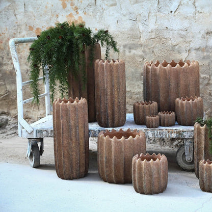 Brigett Copper Cement Pot Ribbed Round High L van PTMD, koperkleurige geribbelde pot in een sfeervolle interieursetting