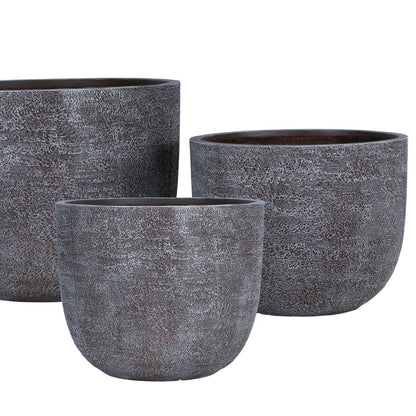 Delsey Brown GRC Structure Pot Big Set Of 3 van PTMD, set van drie bruine potten met structuur in een sfeervolle buitensetting