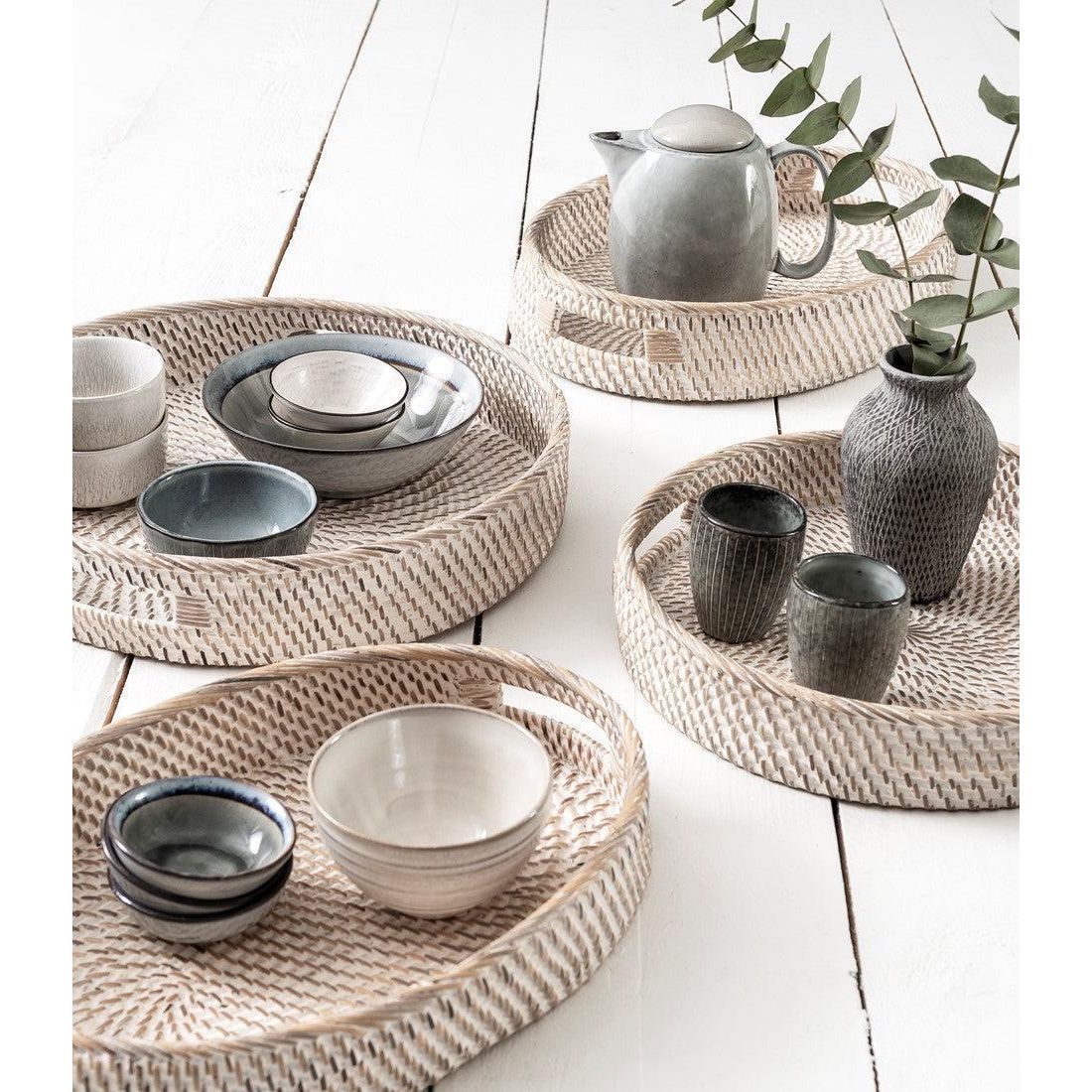 Ovale witte rotan dienbladen Saint Barths van MUST Living gestyled op tafel met glazen en kaarsen