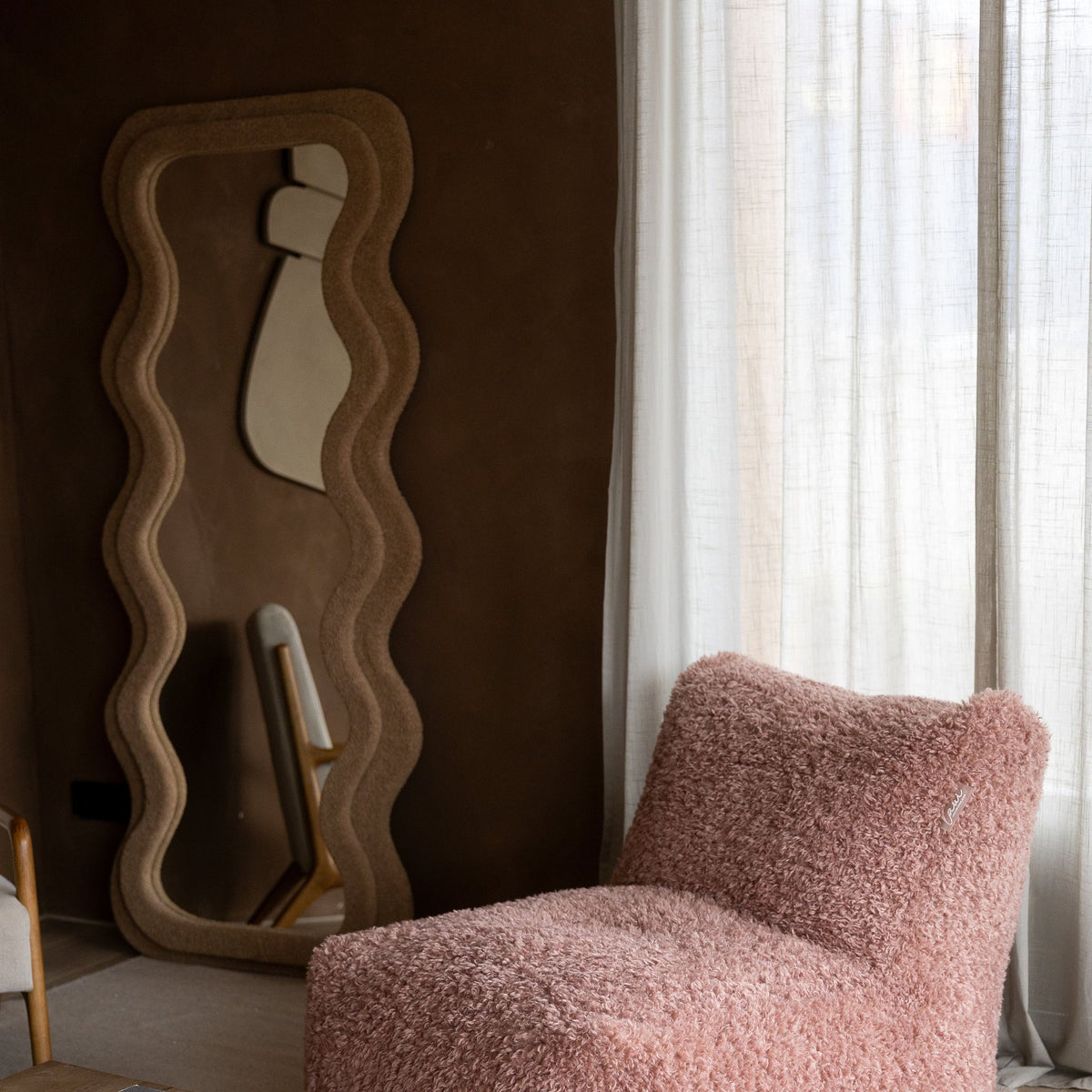 Poederroze Doodle loungestoel van Laui Lounge in een lichte kamer met plaid en decoratie