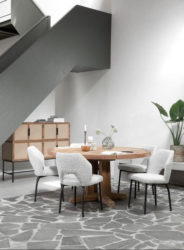 Eetkamerstoel Bloom van MUST Living in licht grijs bouclé bij een gedekte eettafel