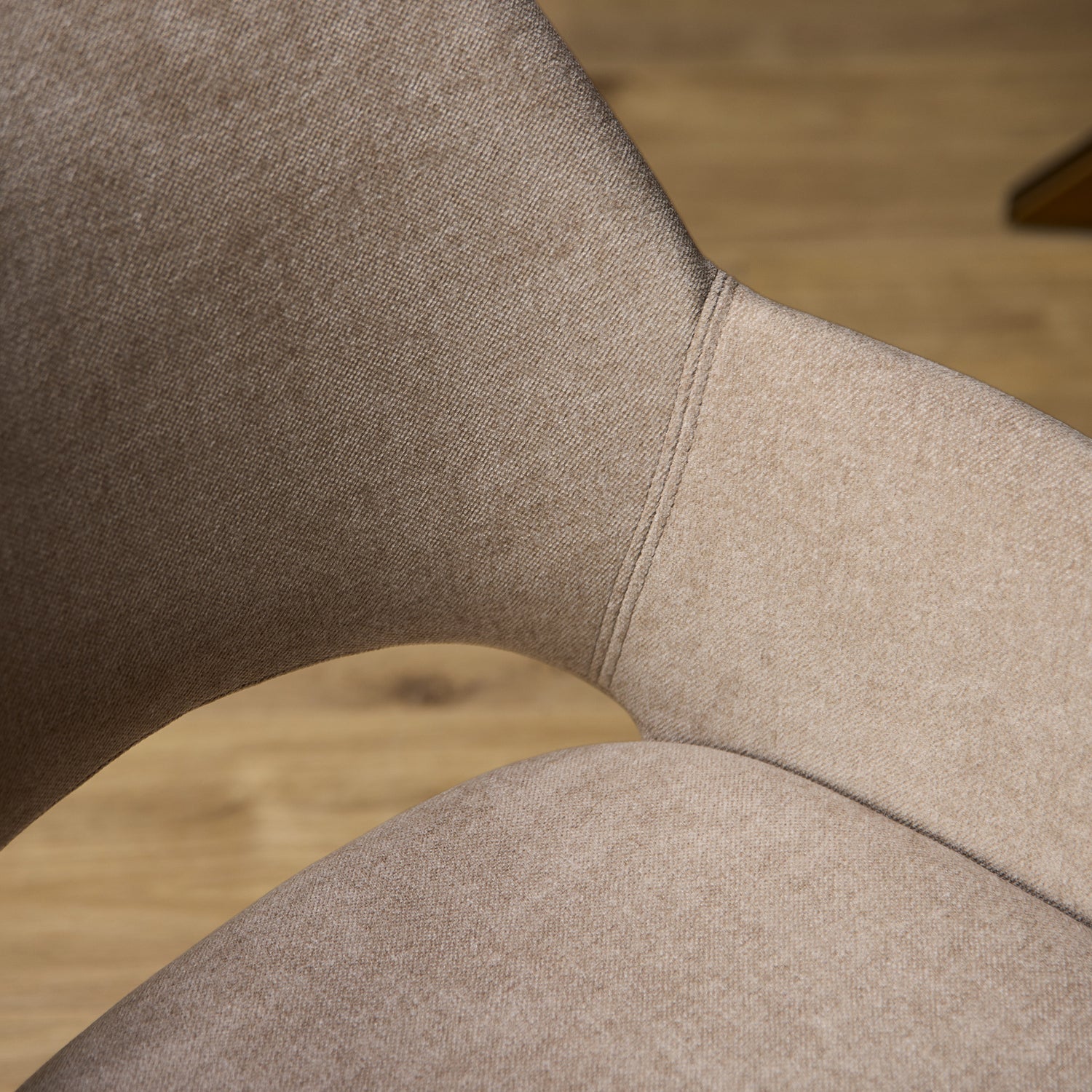 Detail van de zachte beige stof en stiksels van eetkamerstoel Daisy