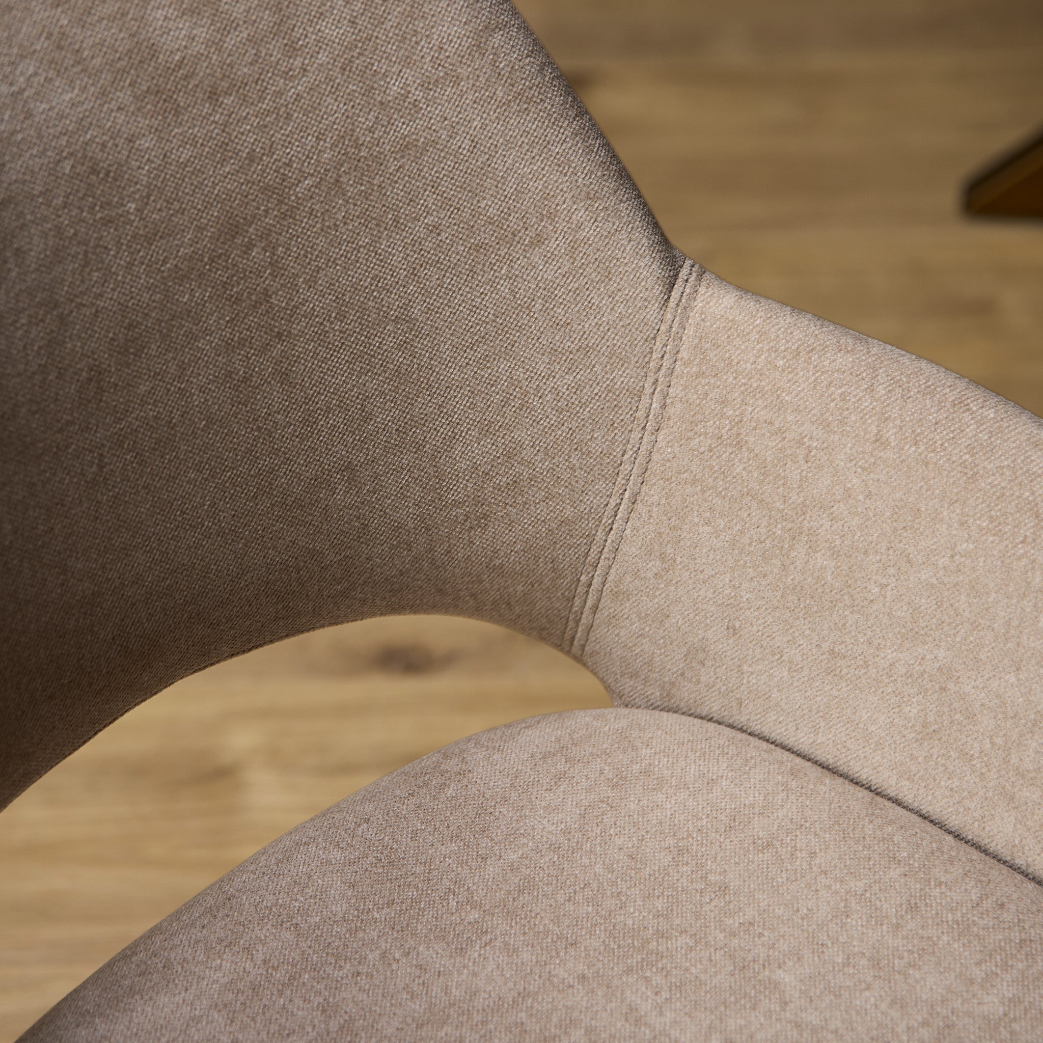 Detail van de zachte beige stof en stiksels van eetkamerstoel Daisy