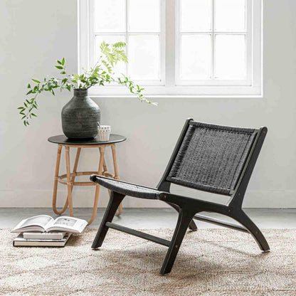 Fauteuil Lazy Loom Zwart van MUST Living schuin van voren, brede zitting met hoge gevlochten rugleuning