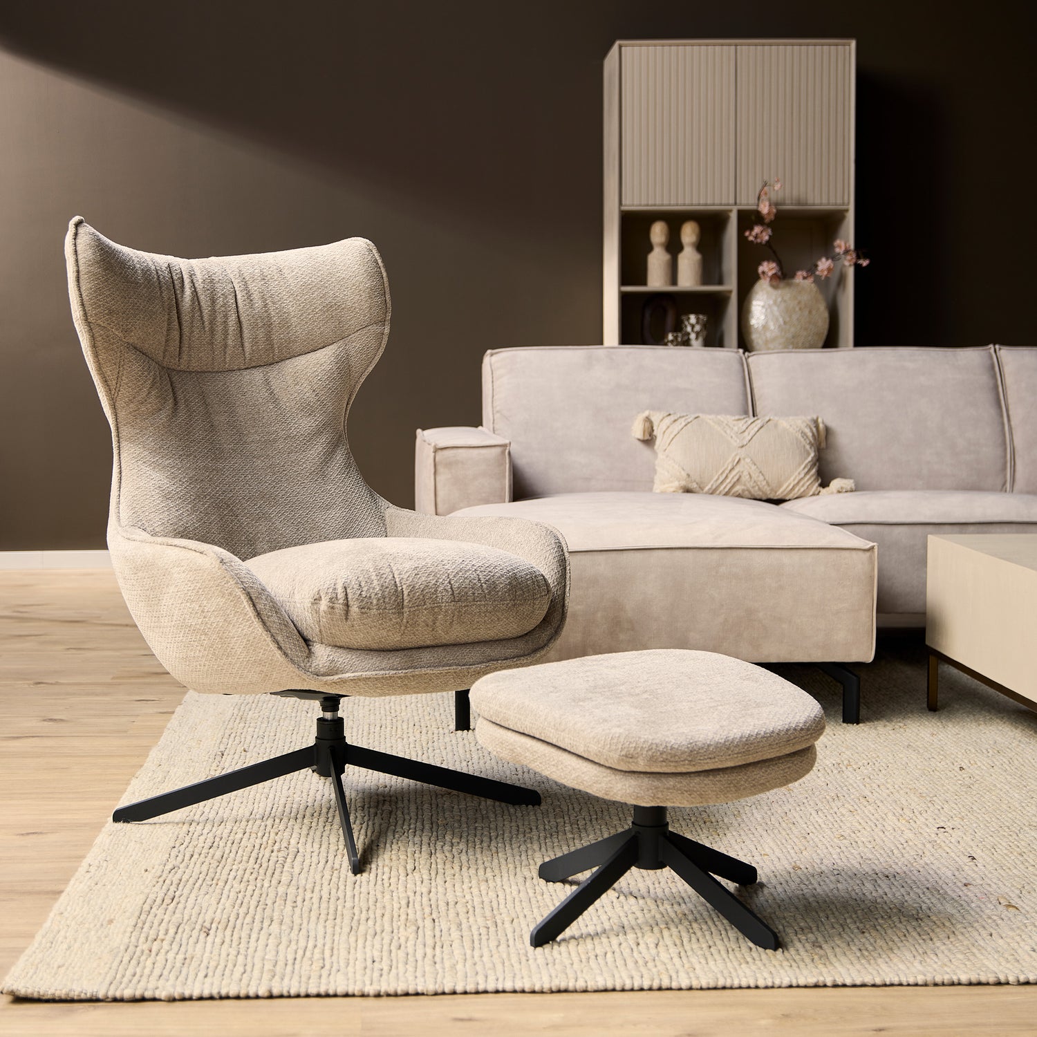 Fauteuil Olivia van Starfurn in taupe stof, vooraanzicht met hoge rug en zwarte metalen draaivoet
