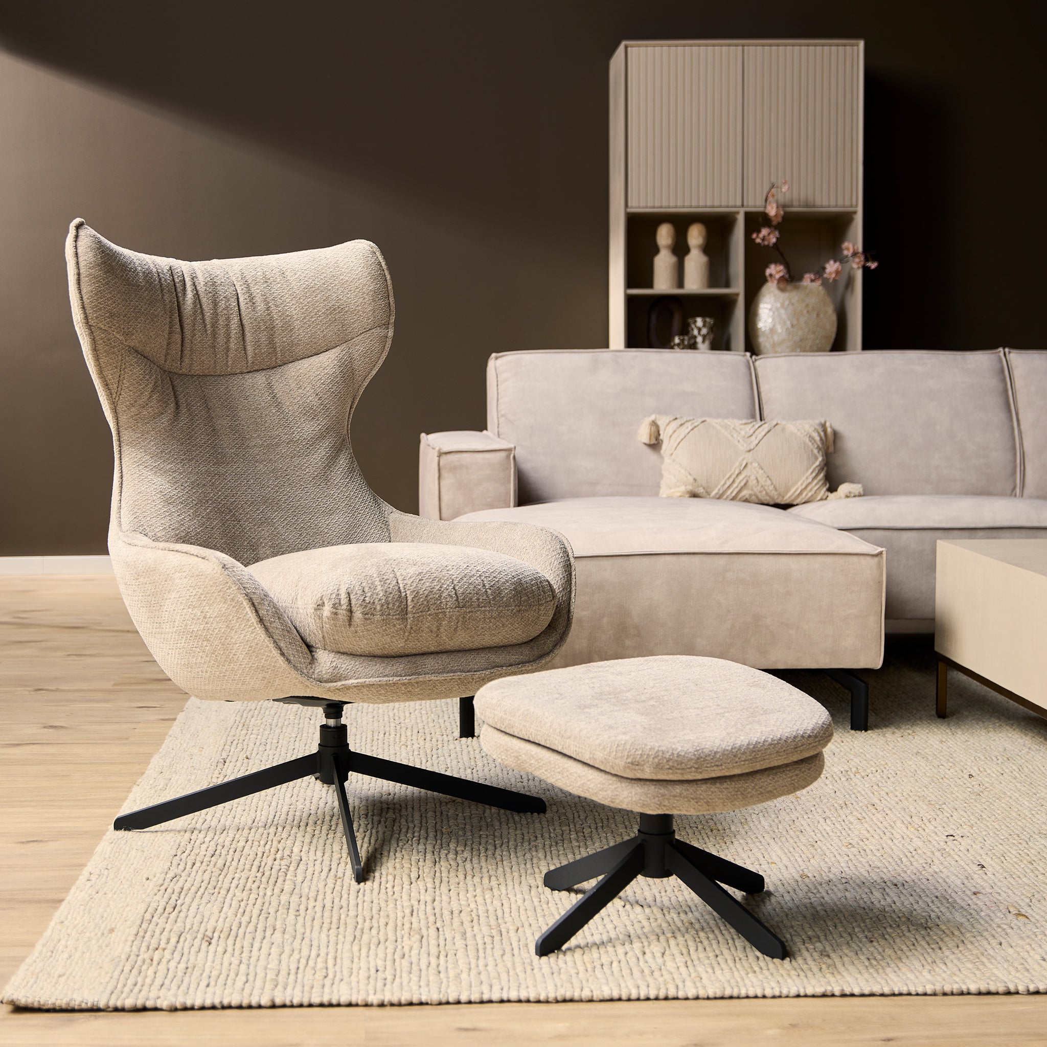 Fauteuil Olivia van Starfurn in taupe stof, vooraanzicht met hoge rug en zwarte metalen draaivoet