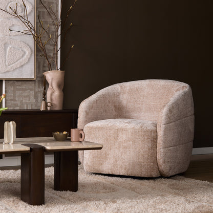 Fauteuil Yara van Starfurn in beige naast een bank met kussens en een plaid