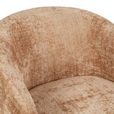 Draaibare fauteuil Yara van Starfurn in een warme woonkamer naast een houten bijzettafel