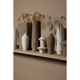 Flesvaas Cavinn Medium van PTMD in mat beige keramiek met takken, in een warm ingerichte kamer
