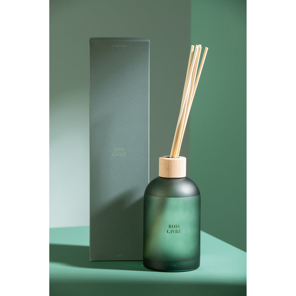 Geurstokjes Accords Essentiels Bois Givré 550ml van J-Line met bijpassende doos in een sfeervolle groene setting