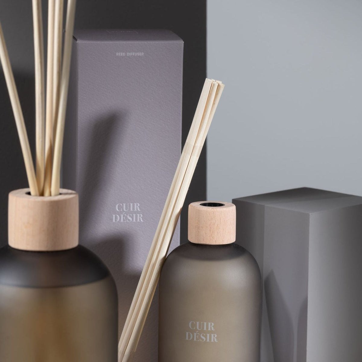 Geurstokjes Accords Essentiels Cuir Désir 250ml van J-Line op decoratieve blokken in een warme sfeerfoto