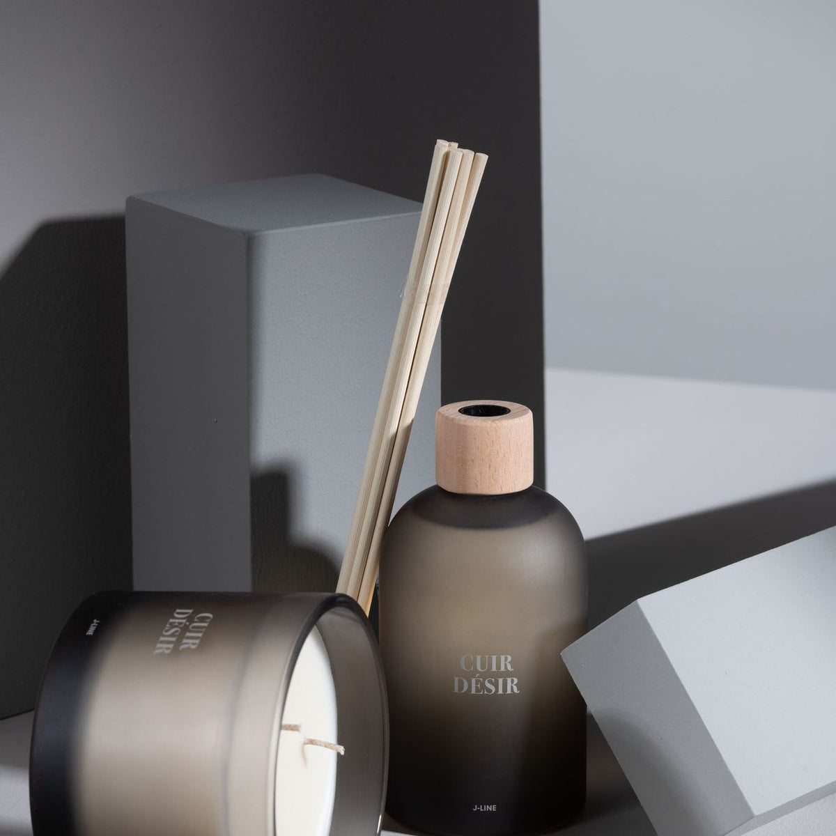 Geurstokjes Accords Essentiels Cuir Désir 250ml van J-Line samen met bijpassende geurkaars uit de Cuir Désir lijn