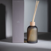 Geurstokjes Accords Essentiels Cuir Désir 550ml van J-Line met bijpassende doos in een sfeervolle bruine setting