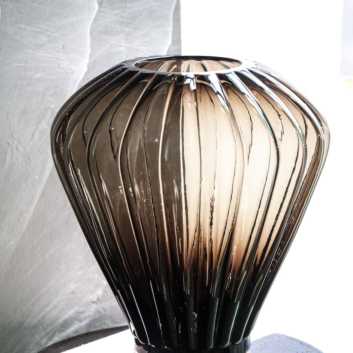 Jayci Brown Glass Solid Glass Ribbed Vase S van PTMD in een sfeervolle woonkamersetting met bloemen
