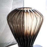 Jayci Brown Glass Solid Glass Ribbed Vase S van PTMD in een sfeervolle woonkamersetting met bloemen