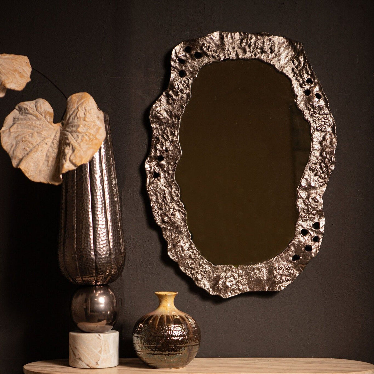 Kariss Bronze Casted Alu Mirror Rough Oval Shape van PTMD, sfeerbeeld van de bronskleurige spiegel aan de wand