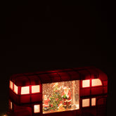 Kerstbus van J-Line met brandende ledverlichting in de ramen in een donkere kamer
