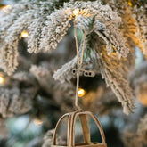 Beige kabelbaancabines van J-Line hangend in een besneeuwde kerstboom met lichtjes