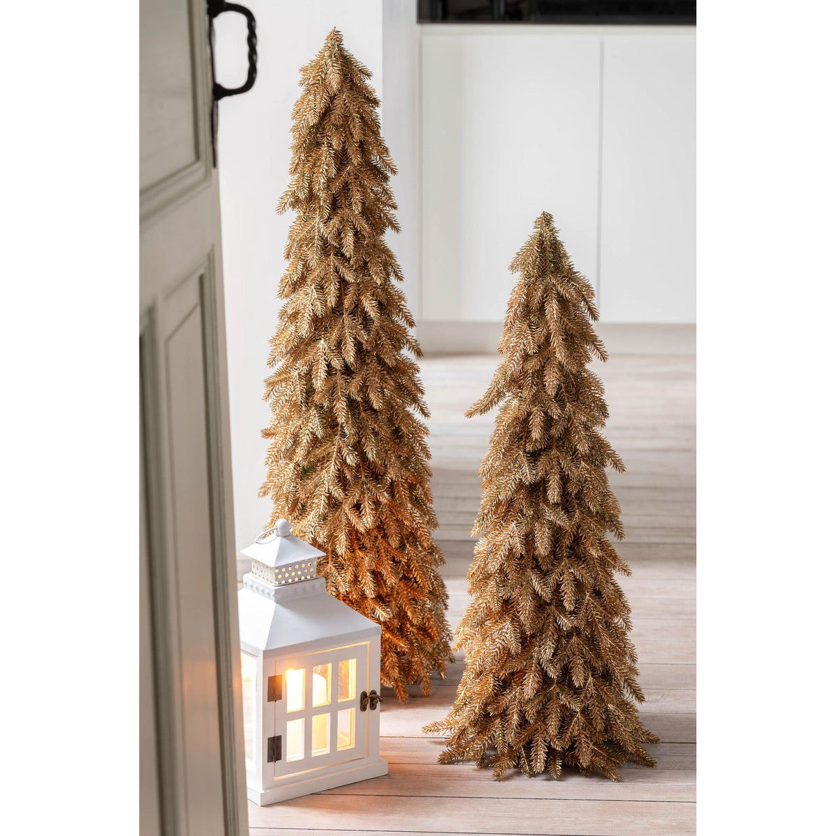 Goudkleurige kunstkerstboom van J-Line, sprankelende takken in een feestelijk gestyled interieur