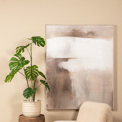 Kunstmonstera van PTMD gestyled in een lichte woonkamer naast een bank