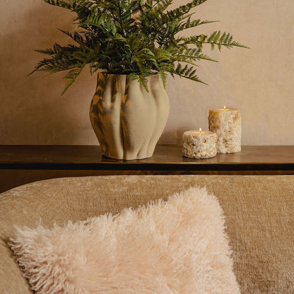 Kunstvaren van PTMD in zwarte pot gestyled op een kast in een lichte woonkamer
