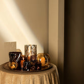 Lenore Gold Luster Windlicht Large van PTMD, sfeervolle opstelling met kaarslicht op een bijzettafel met tafelkleed
