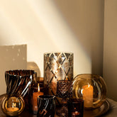 Lenore Gold Luster Windlicht Large van PTMD, close up van gouden windlichten met kaarsen op een dienblad