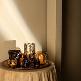 Lenore Gold Luster Windlicht Large van PTMD, windlichten met kaarsen op een ronde tafel bij een boogvormige nis