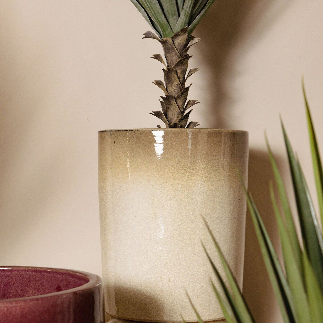 Madsen potten van PTMD in een woonsetting, beige cilinderpotten met planten