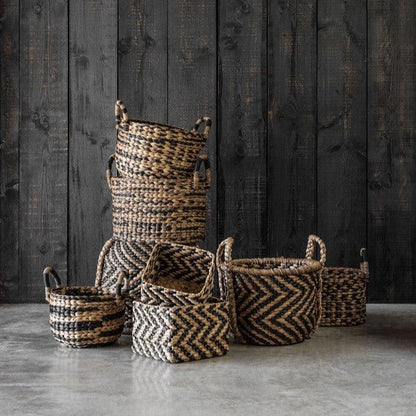 Manden Rond XL van MUST Living, de grootste mand gevuld met plaids naast de bank