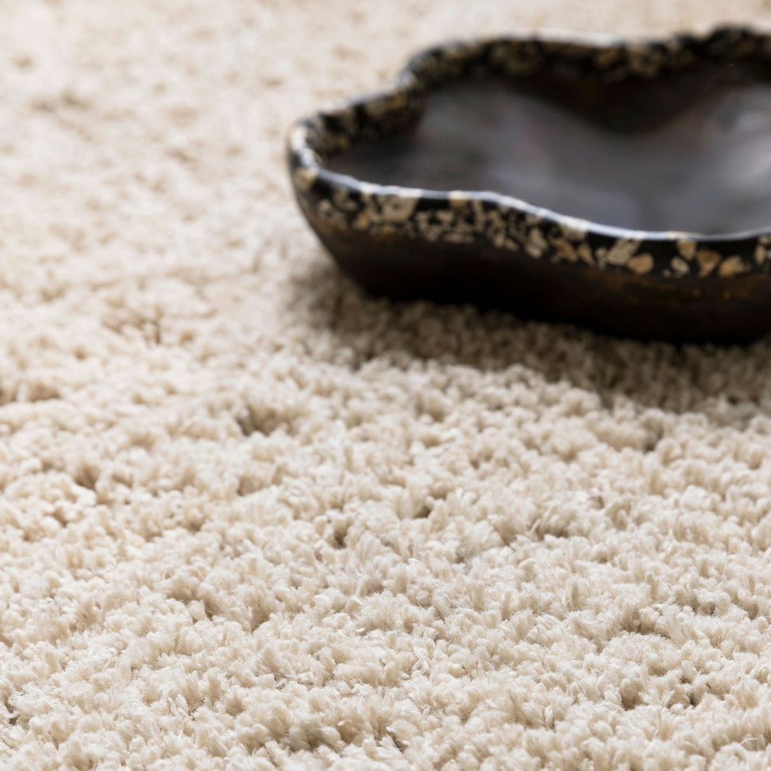 Celeste vloerkleed van MUST Living in beige, close-up van de lange zachte pool met donkere schaal