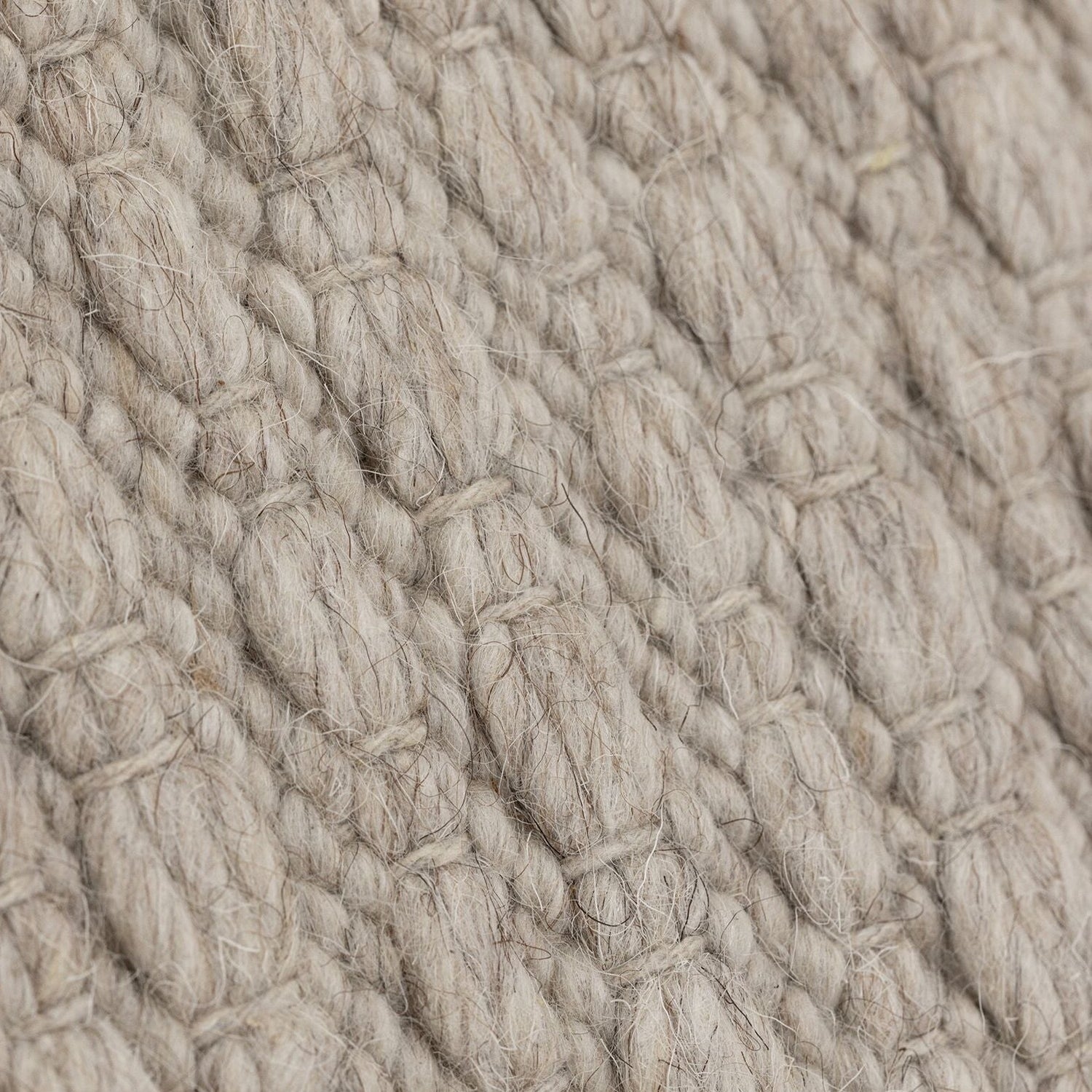 Nirvana vloerkleed van MUST Living in beige, detail van het gevlochten reliëfpatroon in de weving