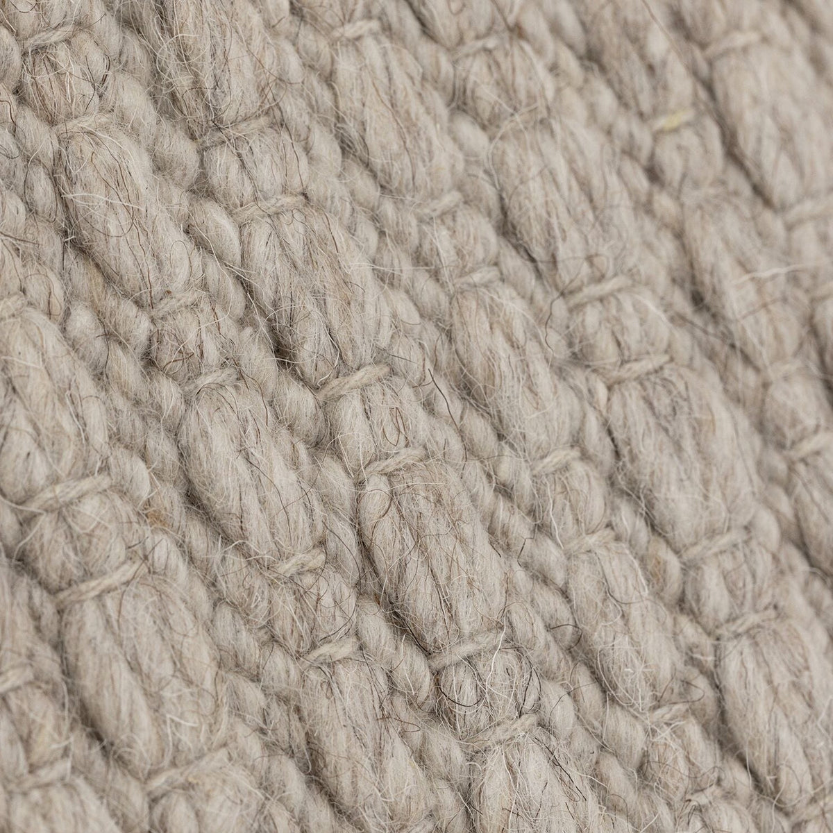 Nirvana vloerkleed van MUST Living in beige, detail van het gevlochten reliëfpatroon in de weving